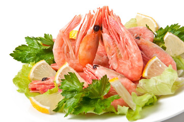 Boiled shrimps with lettuce leaves on plate, isolated on white