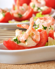 Halves of tomatoes filled with shrimp cocktail 