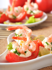 Halves of tomatoes filled with shrimp cocktail 