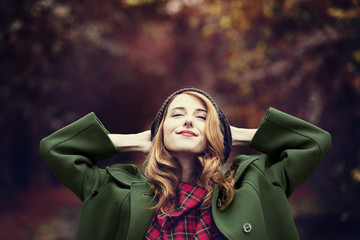 Style redhead girl at beautiful autumn alley.