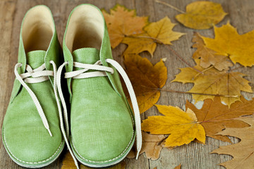 pair of green leather boots and yellow leaves