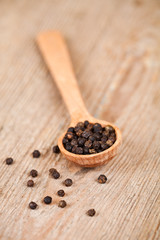 black pepper in wooden spoon