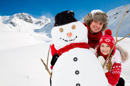 Winter fun, snowman and happy family