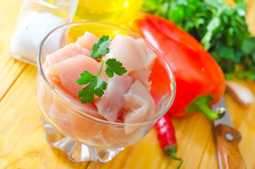 raw chicken and raw vegetables on wooden table