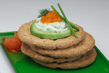 Crispbread with avocado, soft cheese and salmon caviar