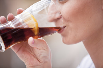 Junge Frau trinkt limonade aus einem Glas