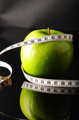 green apple surrounded by white tapeline