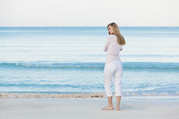 Fototapeta na wymiar Hübsche blonde junge frau entspannt sich alleine am Strand am m