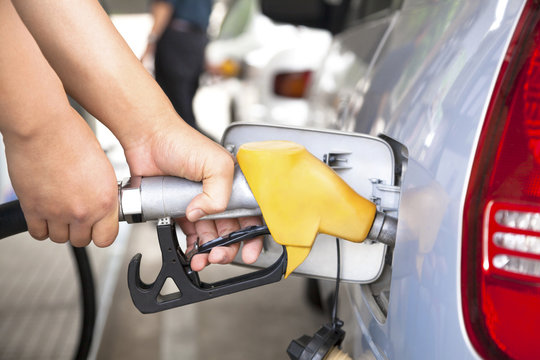 hand refilling the car with fuel on a filling station