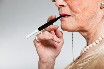 Portrait of good looking senior woman smoking a cigarette.