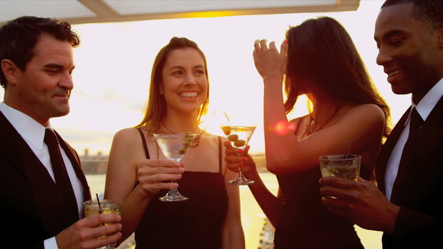 Diverse women and men enjoying together city cocktail roof party 