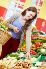 Frau kauft Gemüse im Bioladen