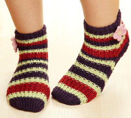 Legs female in striped socks on laminate floor