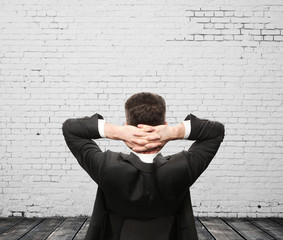 businessman sitting in chair in brick room