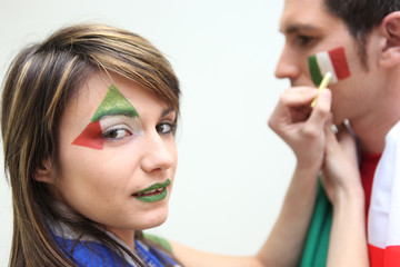 Italian football fans putting on facepaint