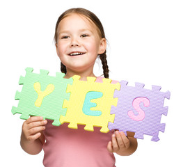 Cute little girl is holding Yes slogan