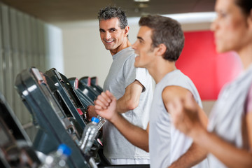 Man Running On Treadmill In Fitness Club