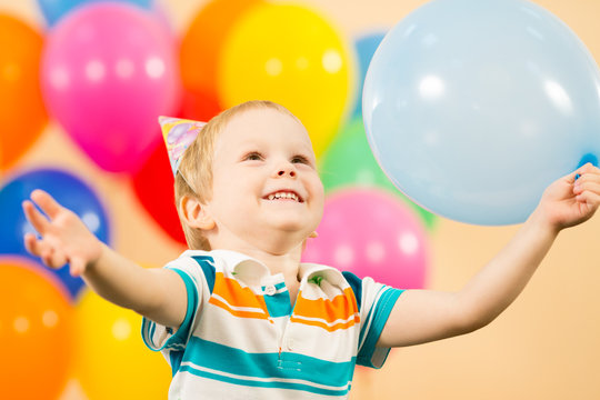 joyful kid boy with balloons on birthday party