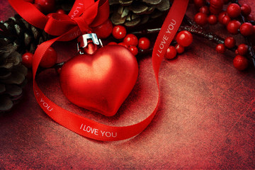 Heart Christmas ornament and ribbon on textured background