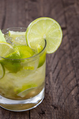 Glass with Caipirinha on wood