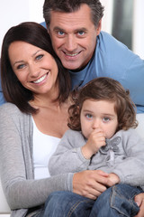 Smiling parents and their little girl