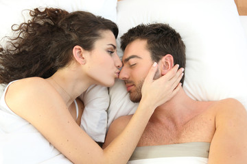 Couple kissing in bed