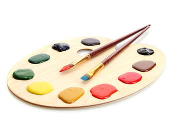 wooden art palette with  paint and brushes.isolated on white