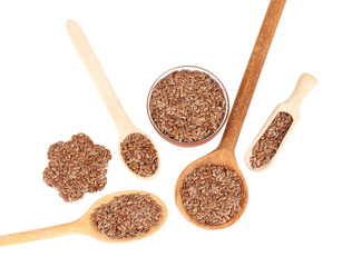 flax seeds in wooden spoons on white background close-up