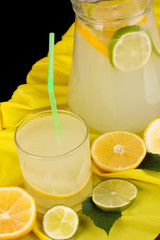 Citrus lemonade in glass and pitcher of citrus around