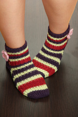 Legs female in striped socks on laminate floor