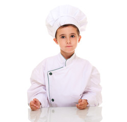 Little boy chef in uniform looking at camera