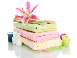 Obraz na płótnie Canvas towels with lily, aroma oil, candles and sea salt isolated