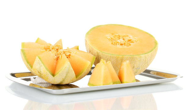Cut melon on metal tray isolated on white