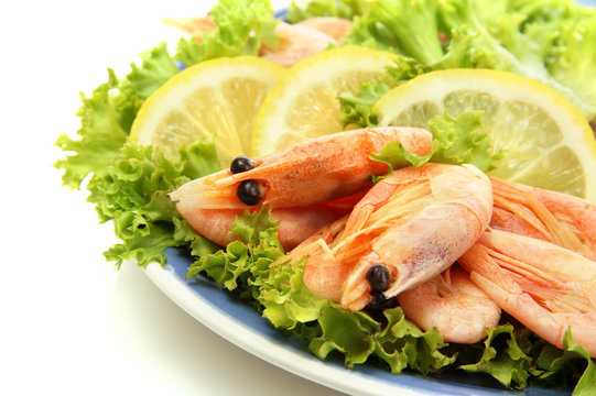 Boiled shrimps with lemon and lettuce leaves