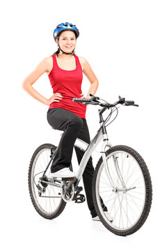 Female bicyclist posing on a bicycle and giving a thumb up
