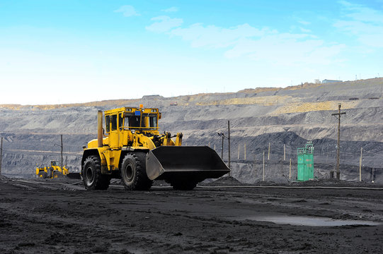 Yellow bulldozer goes in the coal mine. Желтый бульдозер в угольном карьере