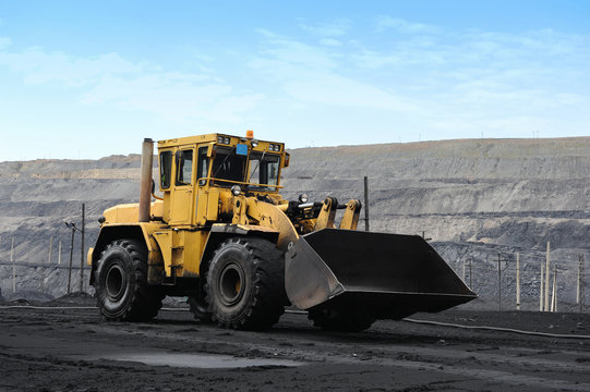 Yellow bulldozer goes in the coal mine. Желтый бульдозер едет в угольном карьере