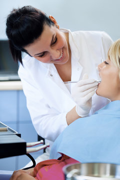 female dentist examining patient`s teeth