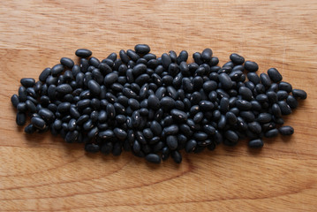 Pile of black beans on wooden background