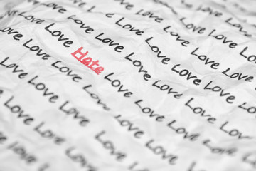 The word hate, love written on a crumpled piece of closeup.