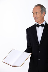 Grey haired restaurant worker presenting menu