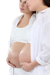 pregnant woman looking herself at the mirror