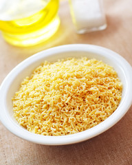 assortment of raw pasta and wheat on wooden background