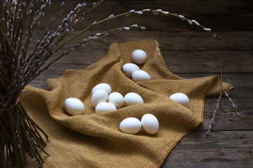 Bunch of willow and white eggs placed on the sack fabric