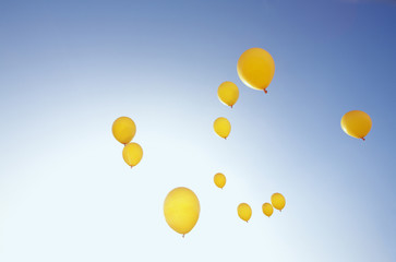 gelbe Luftballons im blauen Himmel