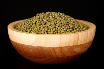 mung beans in wooden bowl isolated on black