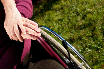 Mehrere Hände berühren sich, eine Person sitzt im Rollstuhl