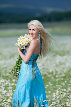 Attractive blonde in chamomile field