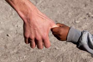 Armes Kind an Hand von Entwicklungshelfer