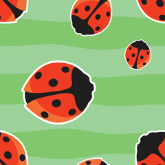 Bright seamless pattern with red ladybirds on green background